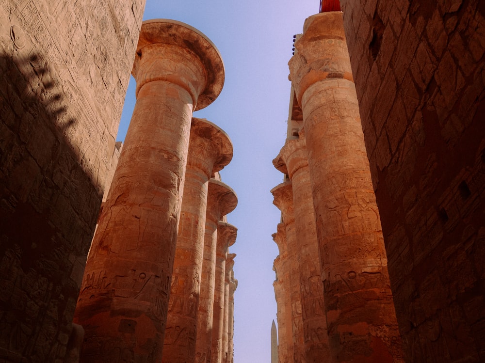 a narrow street lined with stone pillars under a blue sky