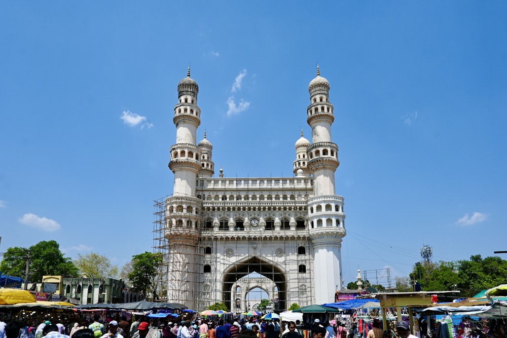 a group of people standing in front of a tall white building