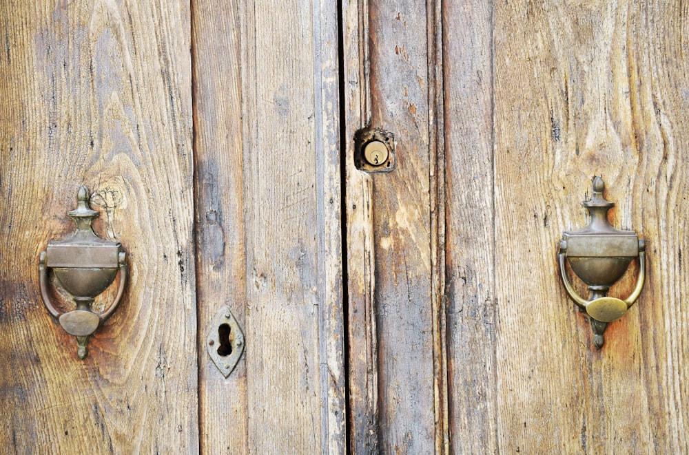 a close up of a wooden door with metal handles