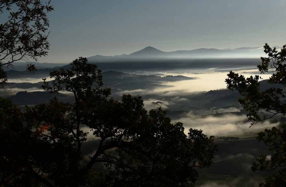 el sol brilla a través de las nubes sobre las montañas