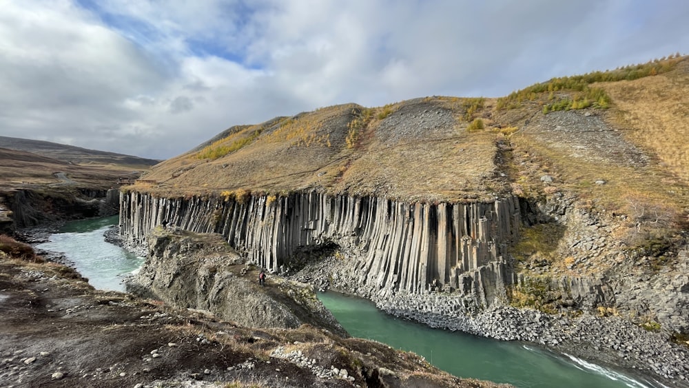 a river running through a canyon next to a mountain