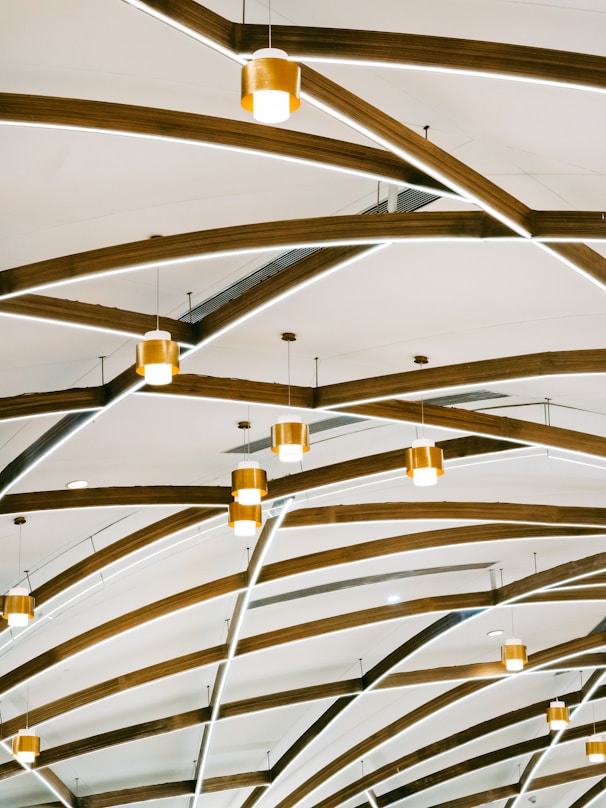 Un techo con vigas de madera y luces colgando de él.