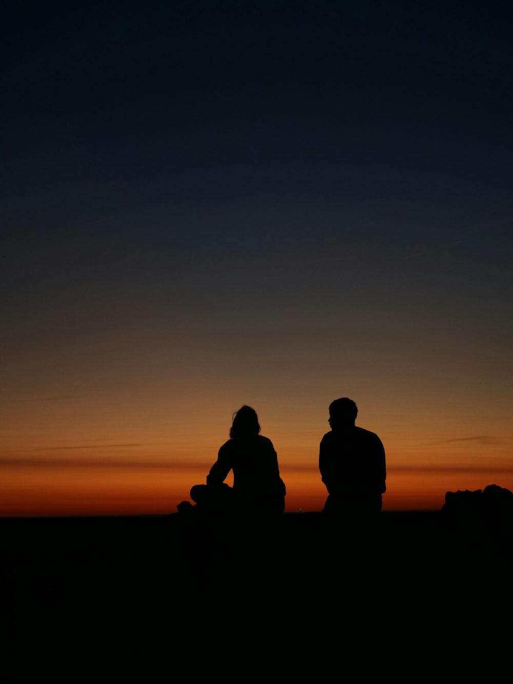 a couple of people sitting on top of a hill