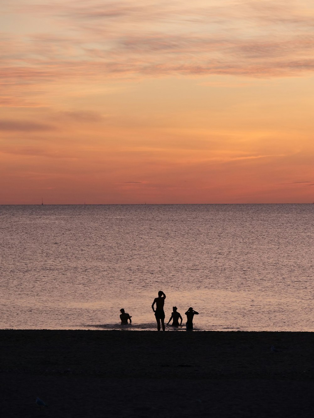 un gruppo di persone in piedi in cima a una spiaggia vicino all'oceano