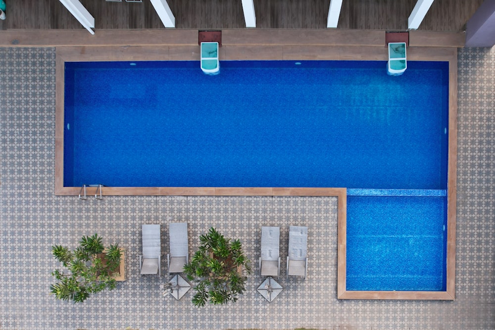 an overhead view of a swimming pool and lounge chairs