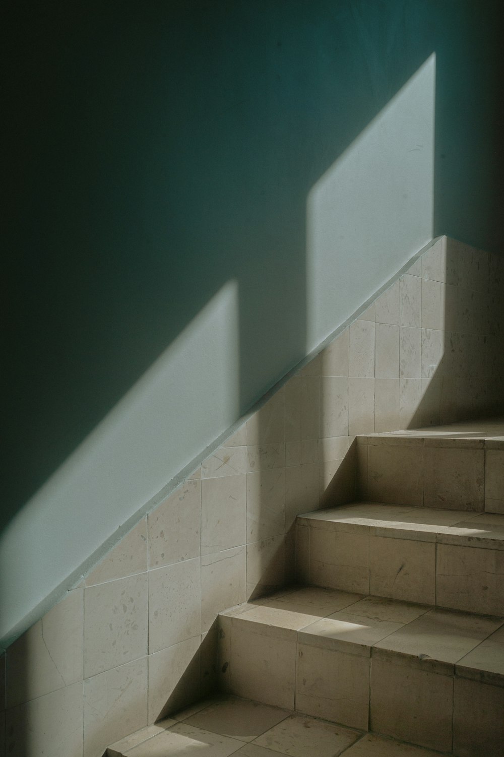 a stair case in a room with a light coming through the window