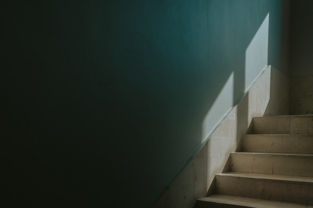 a set of stairs leading up to a green wall