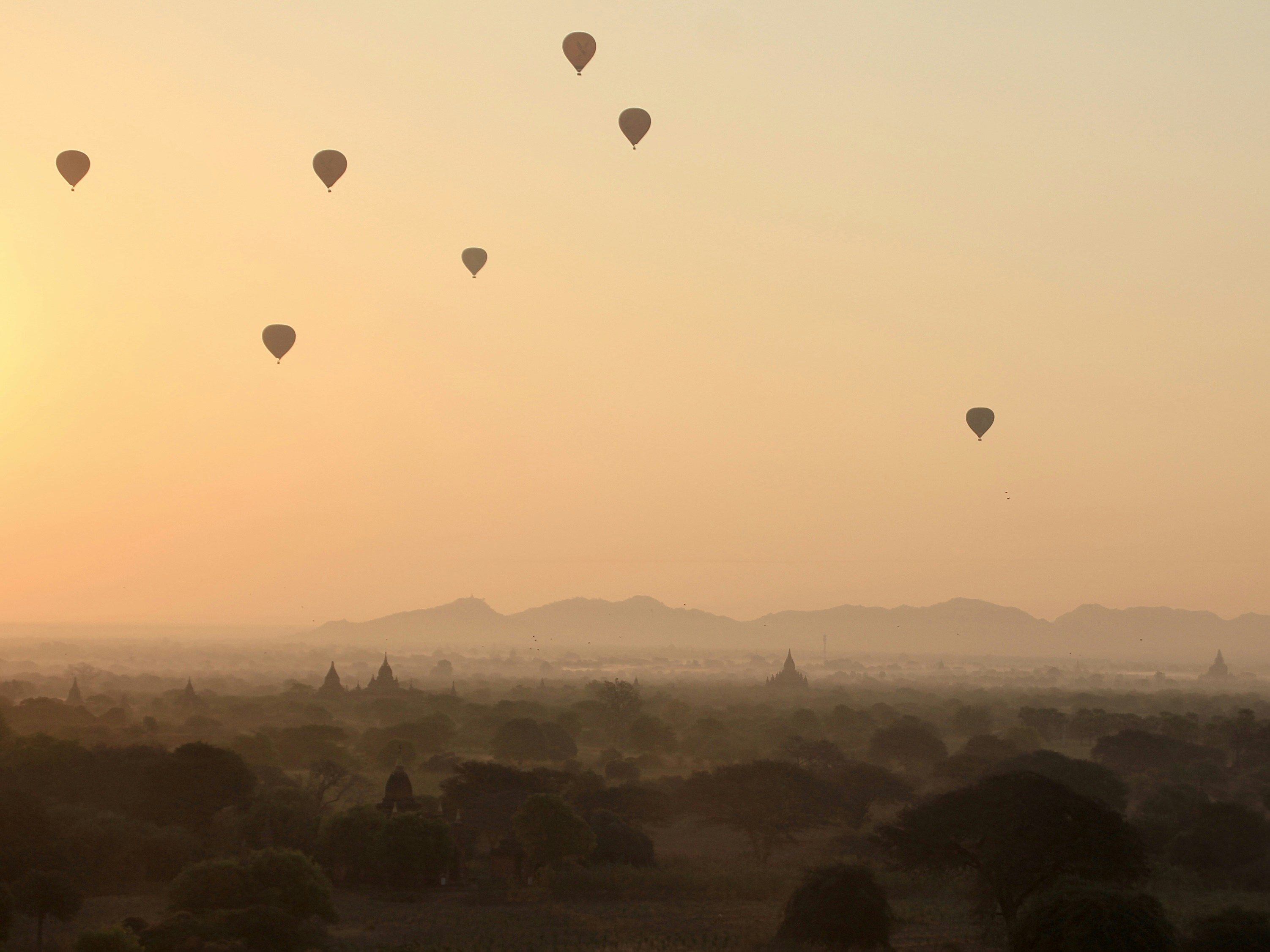 Un grupo de globos aerostáticos volando en el cielo