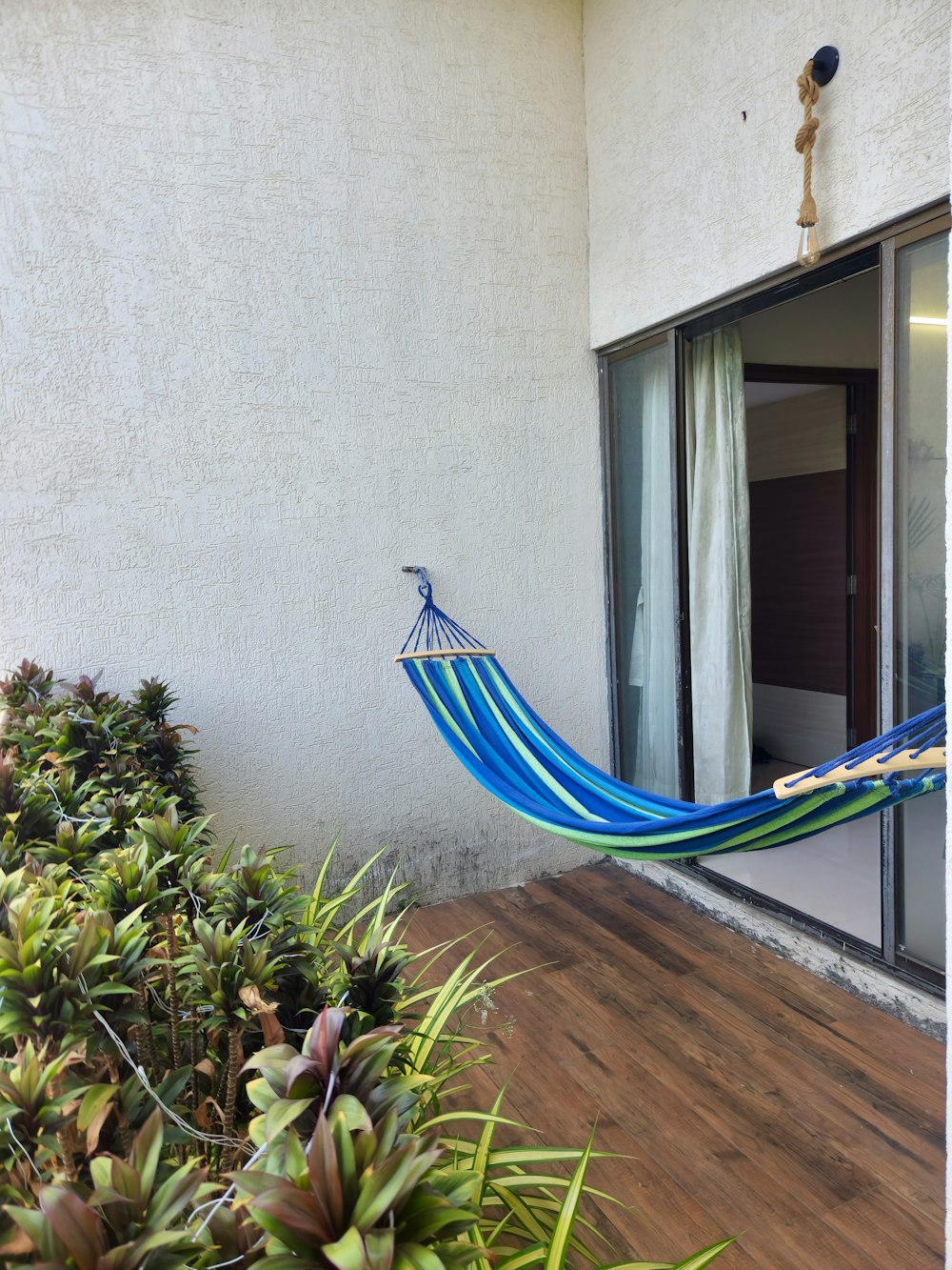 a blue hammock hanging from the side of a house
