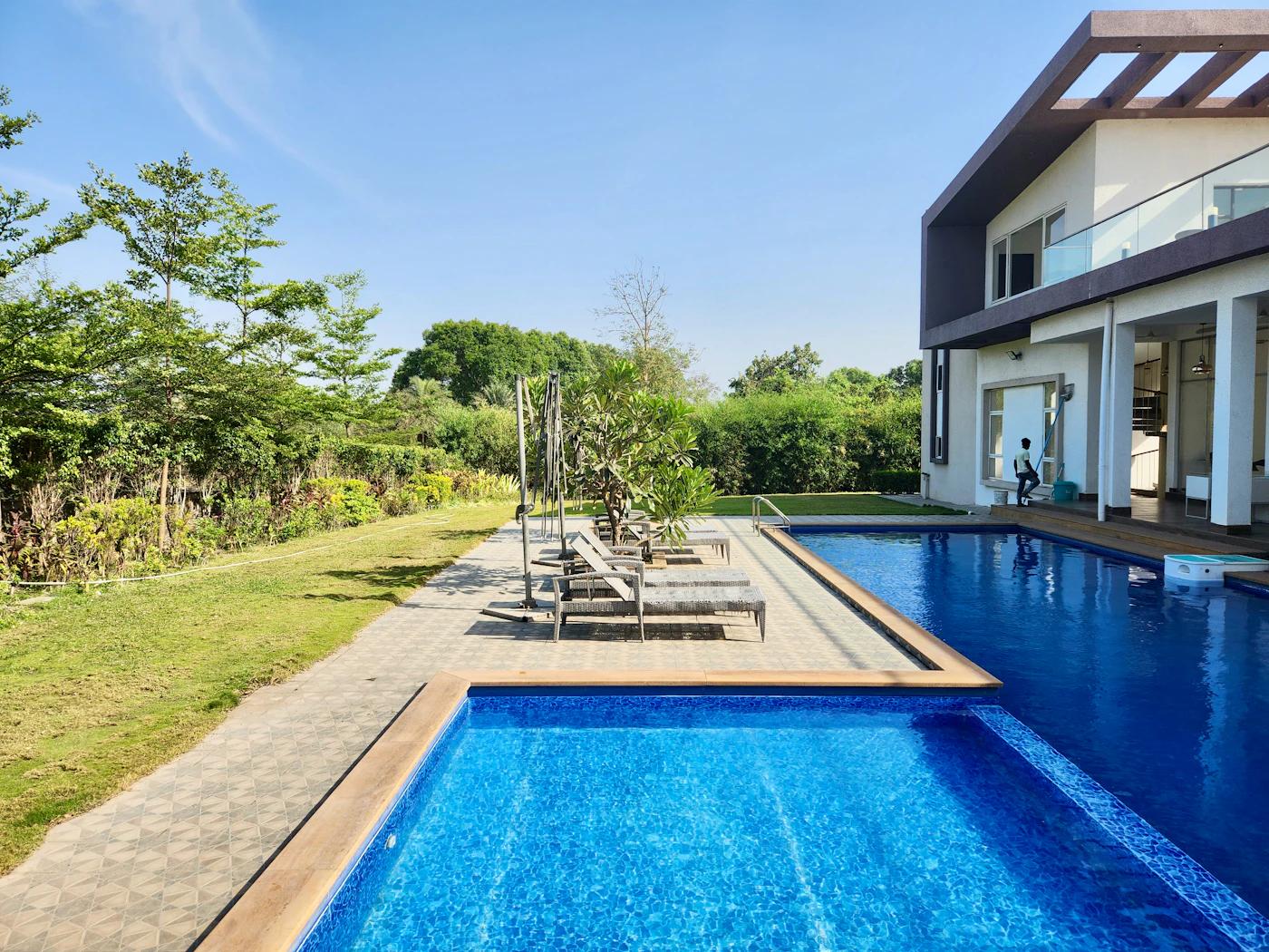 Clean blue swimming pool beside a modern home