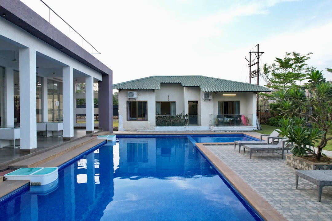 a house with a pool in the middle of it, Luxurious tropical themed outdoor swimming pool