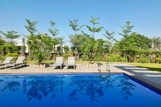 a swimming pool with lounge chairs next to it