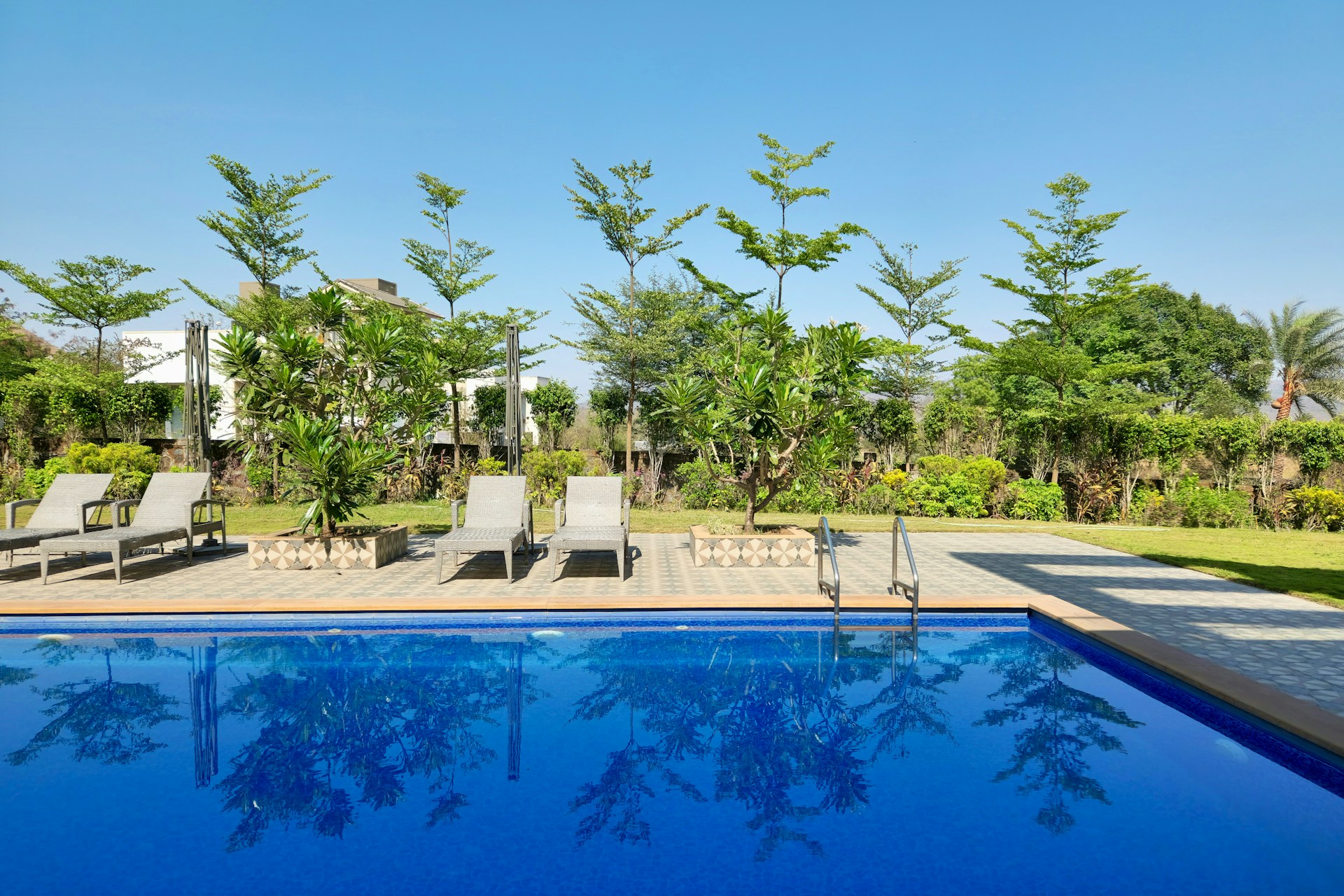 a swimming pool with lounge chairs next to it