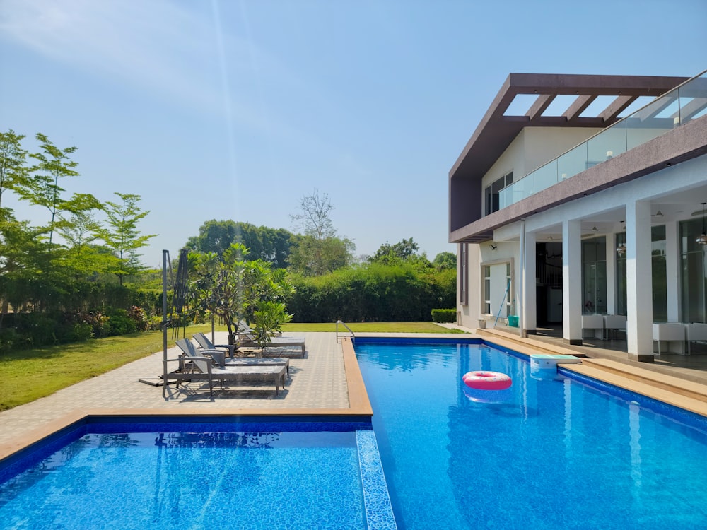 a large swimming pool with lounge chairs and a deck