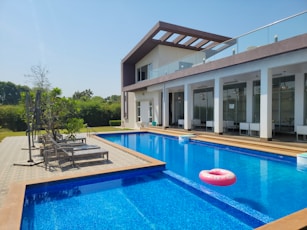 a large swimming pool with a lounge chair next to it