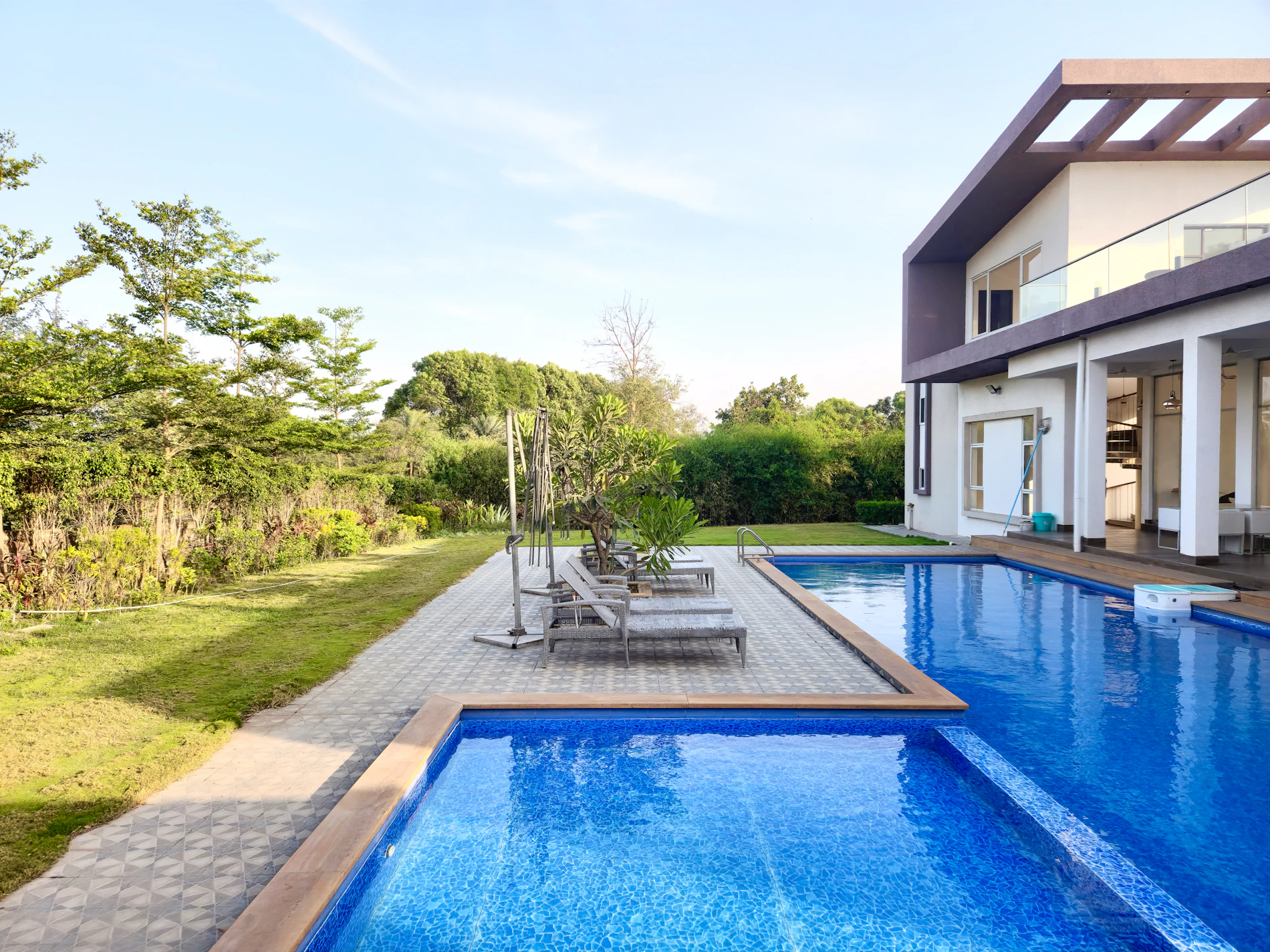 Luxury beach resort swimming pool surrounded by loungers in Daman
