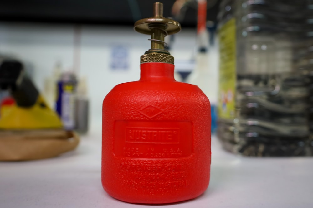 a red propane gas bottle sitting on a table