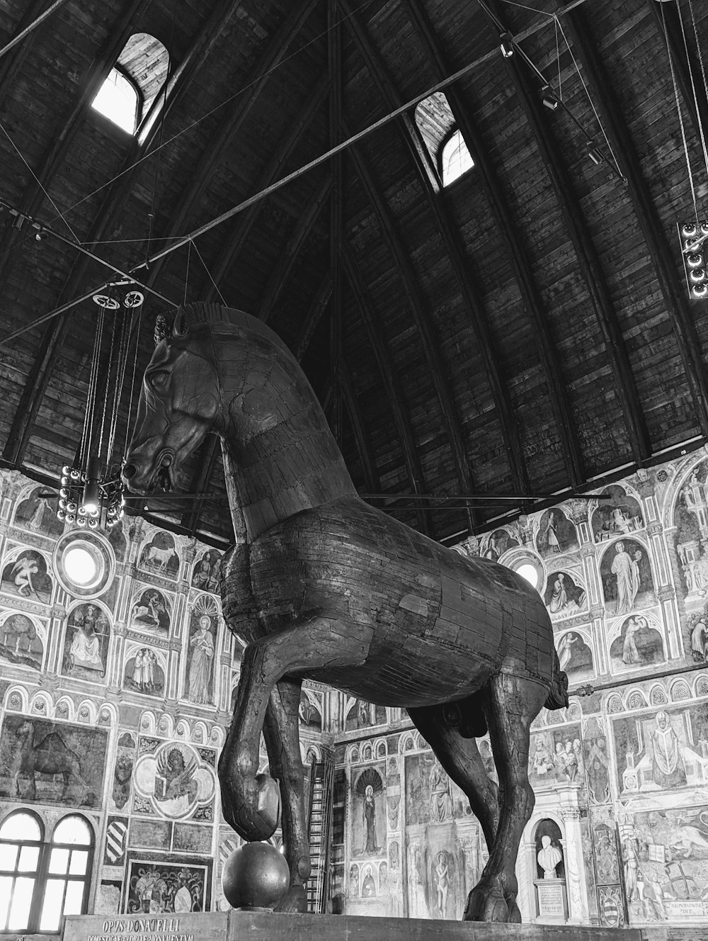 uma grande estátua de cavalo de madeira em um edifício