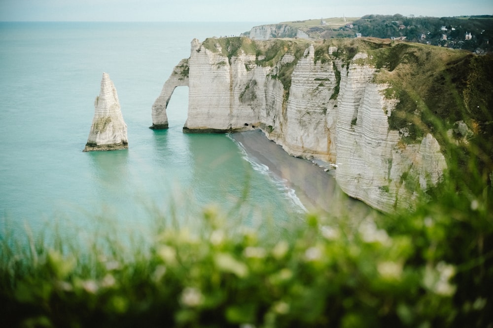 a view of a beach with a rock formation in the water