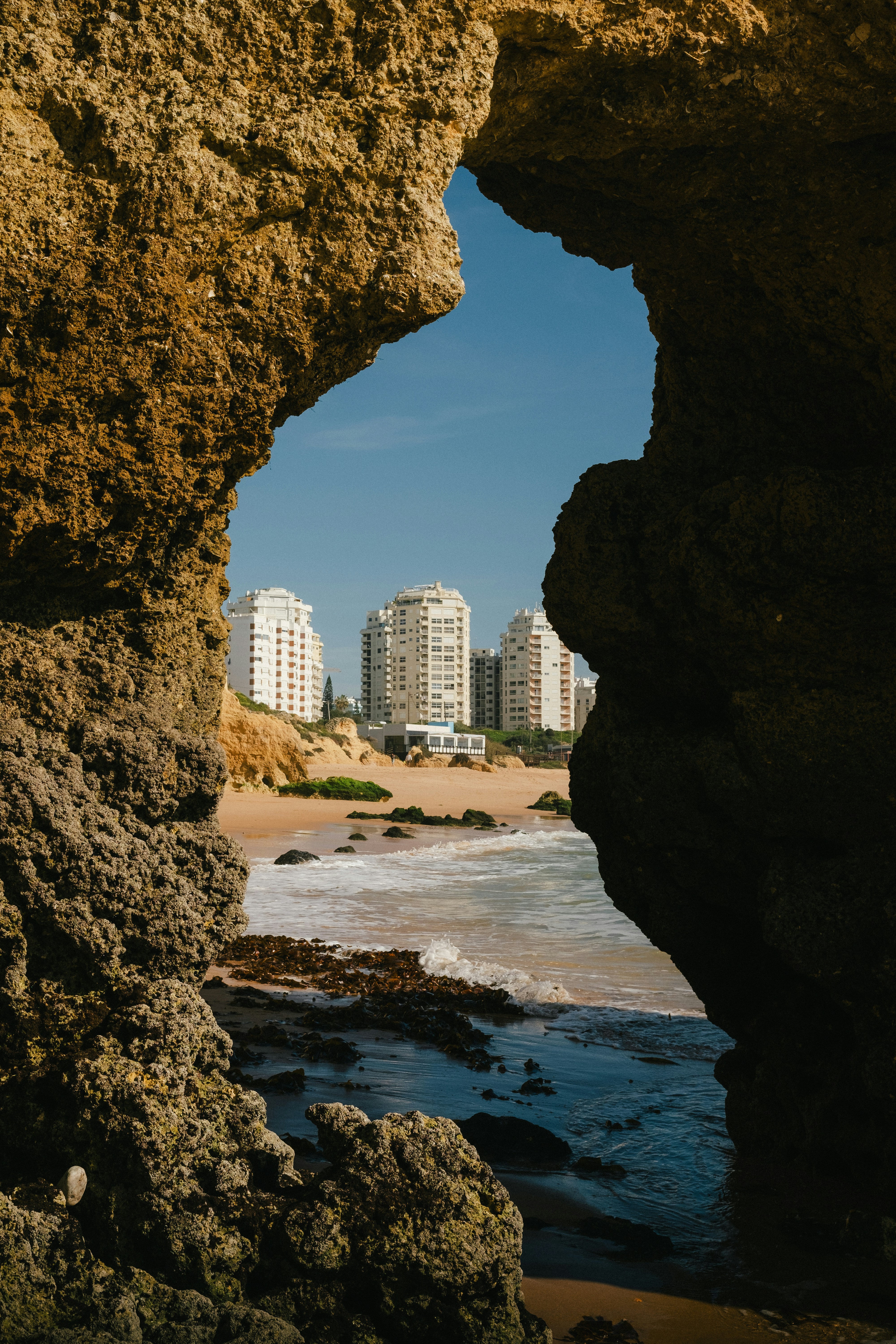 A view of a beach through a hole in a rock photo – Free Portugal Image ...