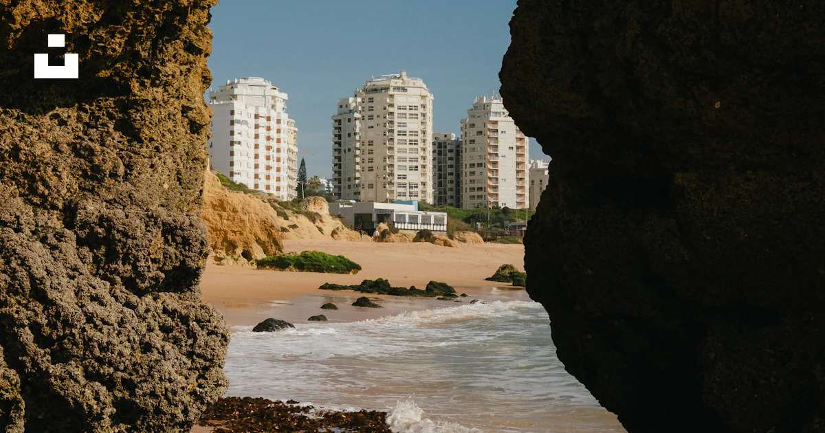 A view of a beach through a hole in a rock photo – Free Portugal Image ...