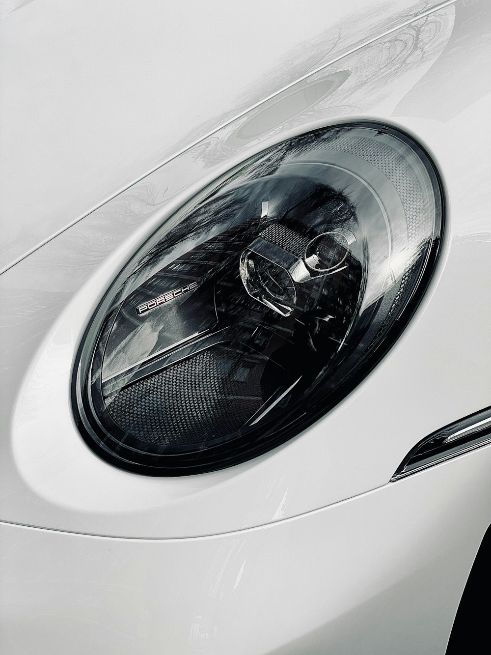 a close up of a white sports car's headlight