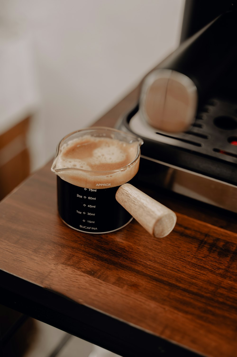 a cup of coffee sitting on top of a wooden table