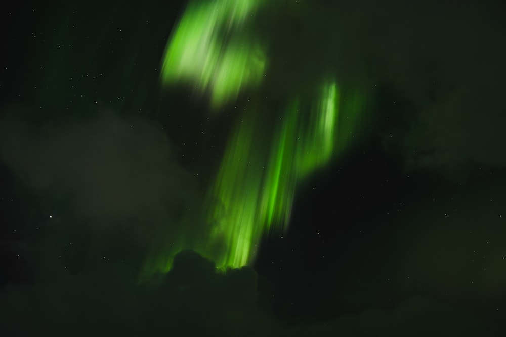 a green and white aurora bore in the night sky