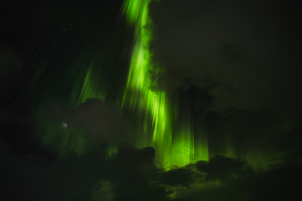 a green and white aurora bore in the night sky