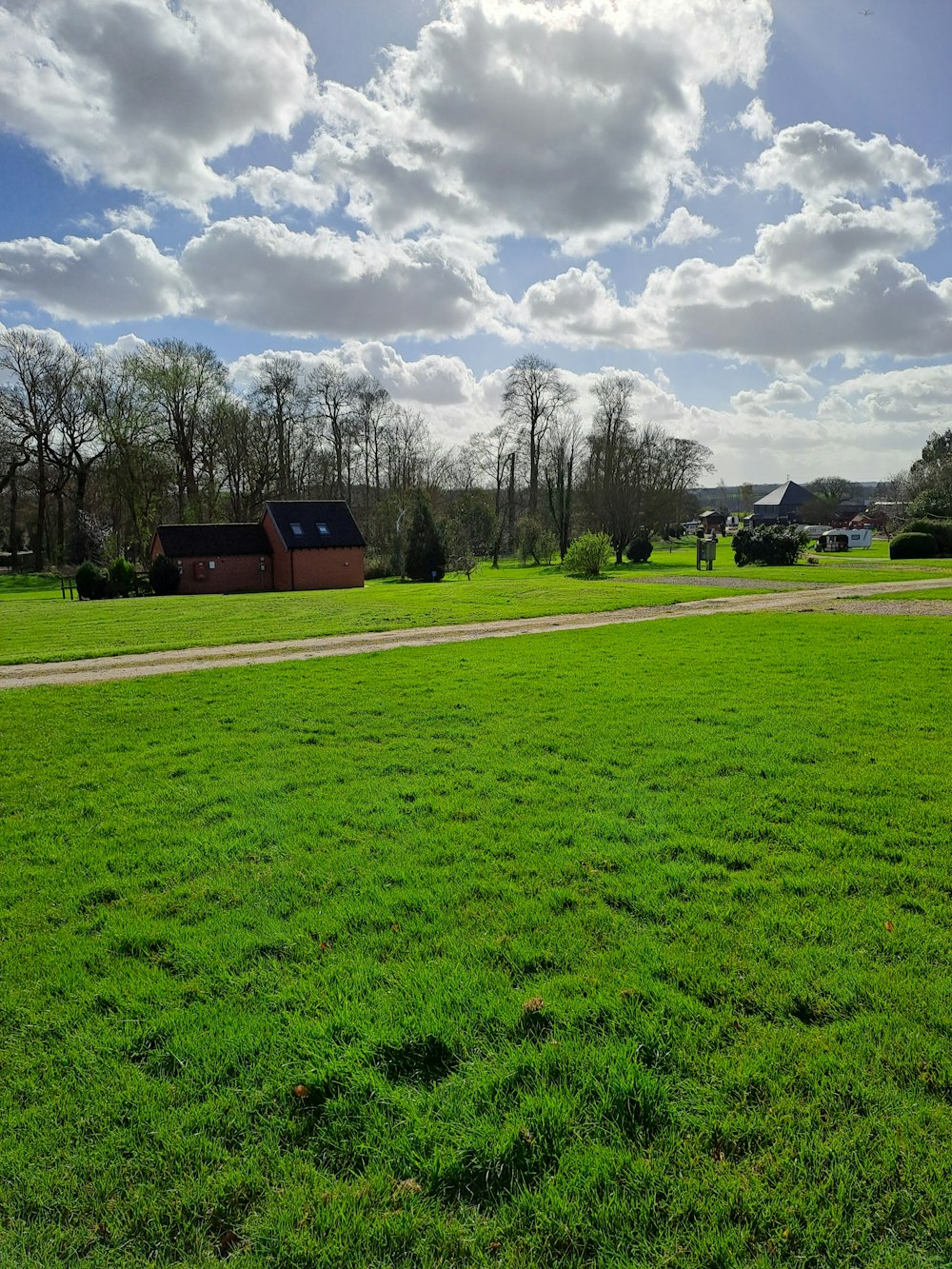 a grassy field with a house in the distance