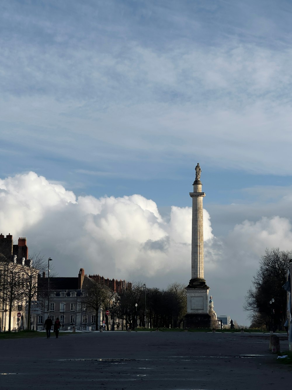 a tall white clock tower sitting in the middle of a street