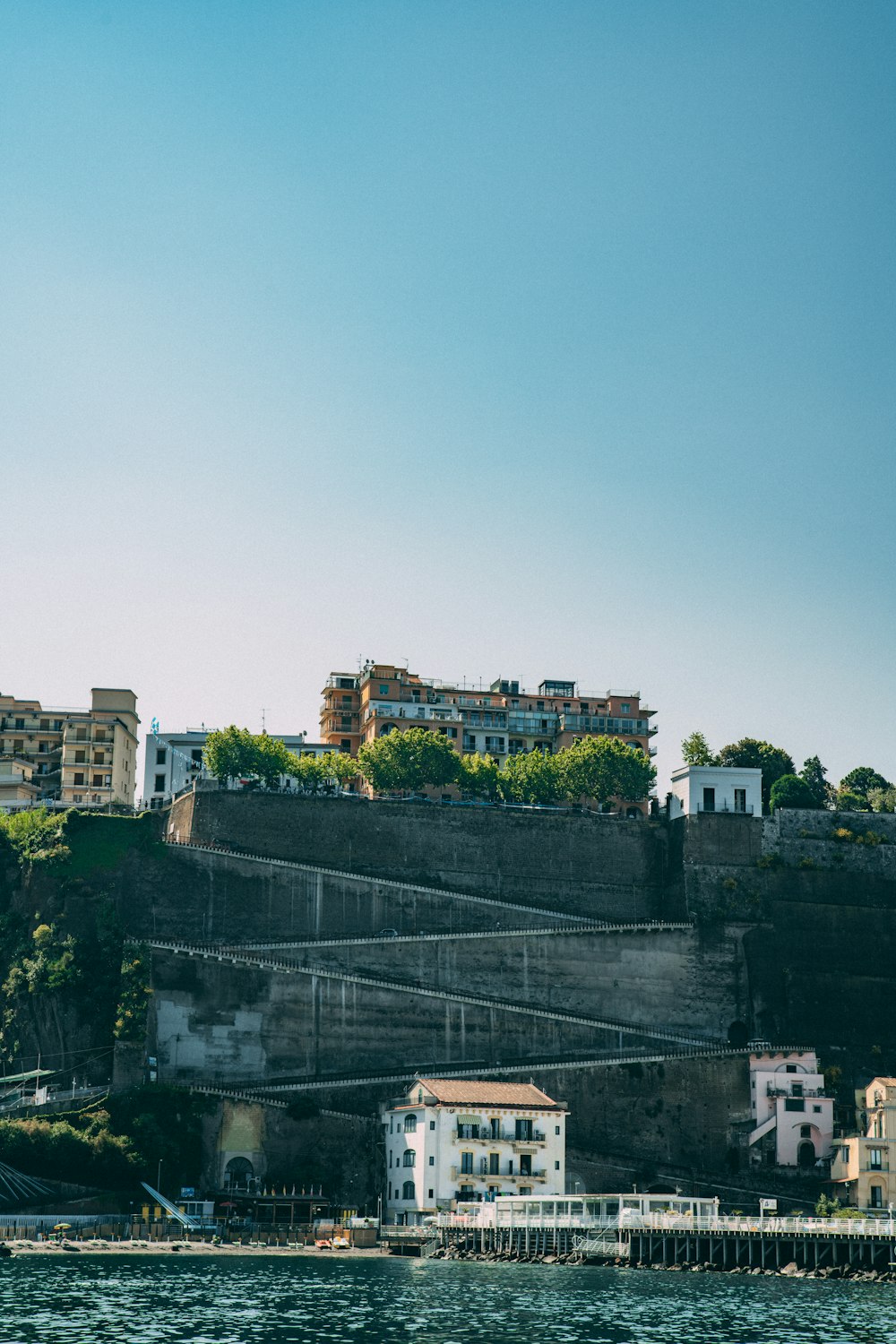 a city on a hill next to a body of water