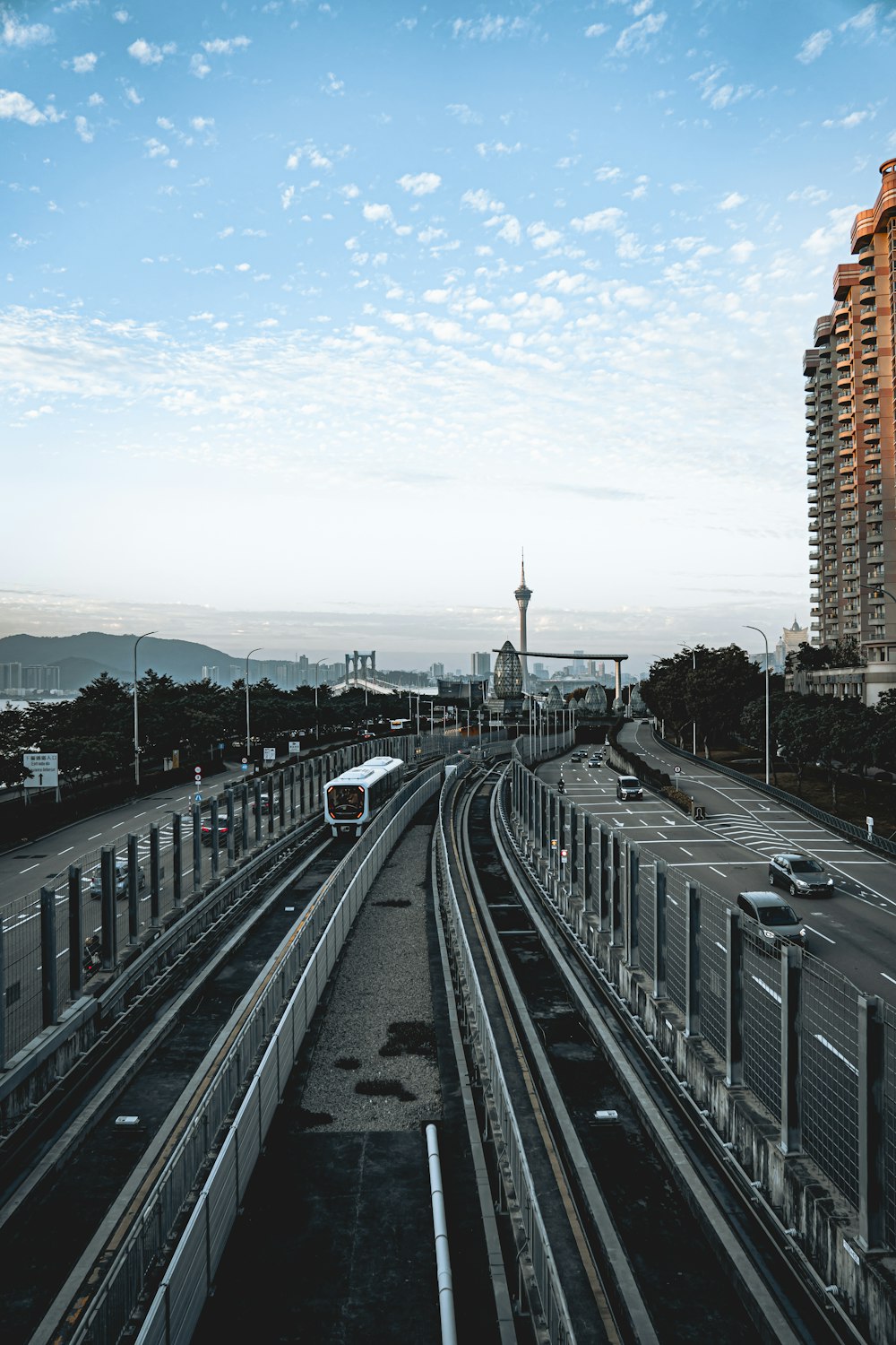 a train traveling down train tracks next to tall buildings