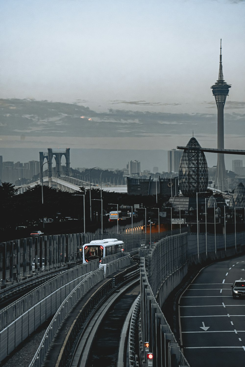 a train traveling down tracks next to a tall building