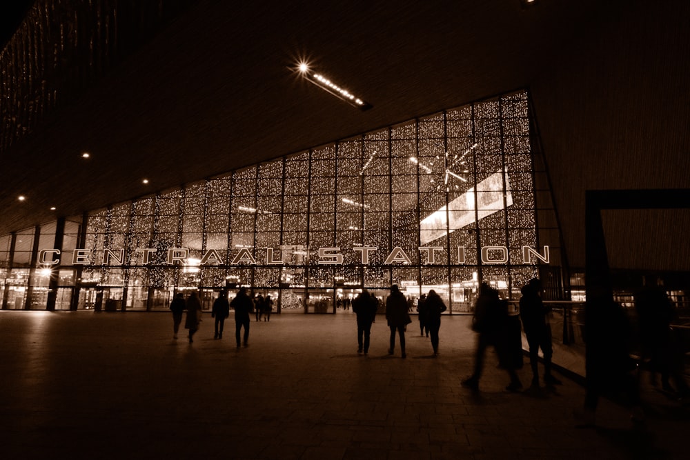 a group of people standing outside of a building at night