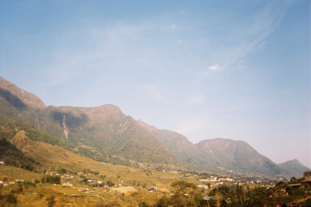 a scenic view of a valley with mountains in the background