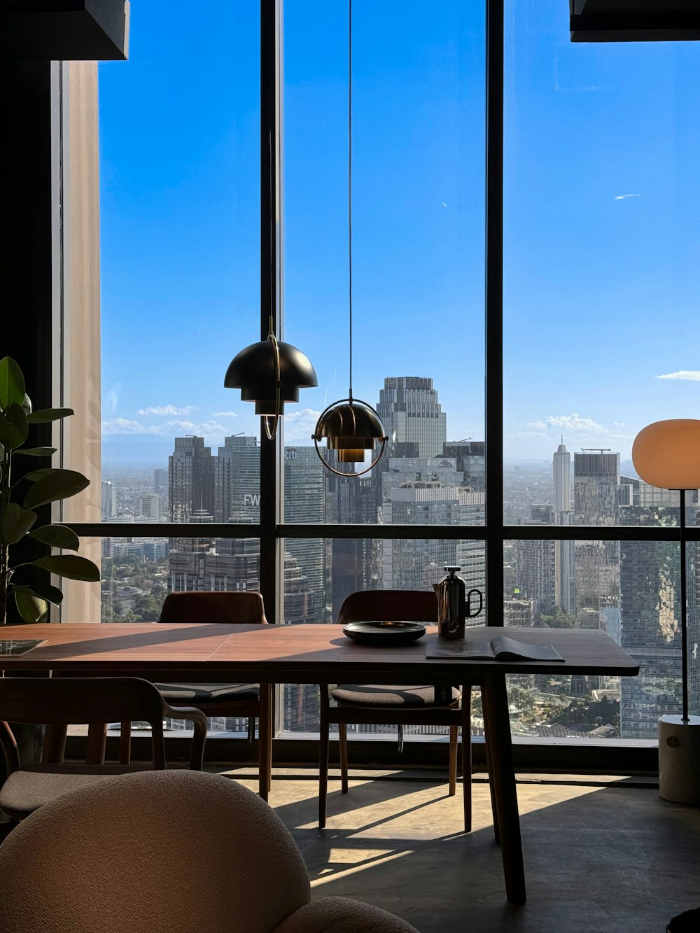 a room with a table, chairs and a view of a city