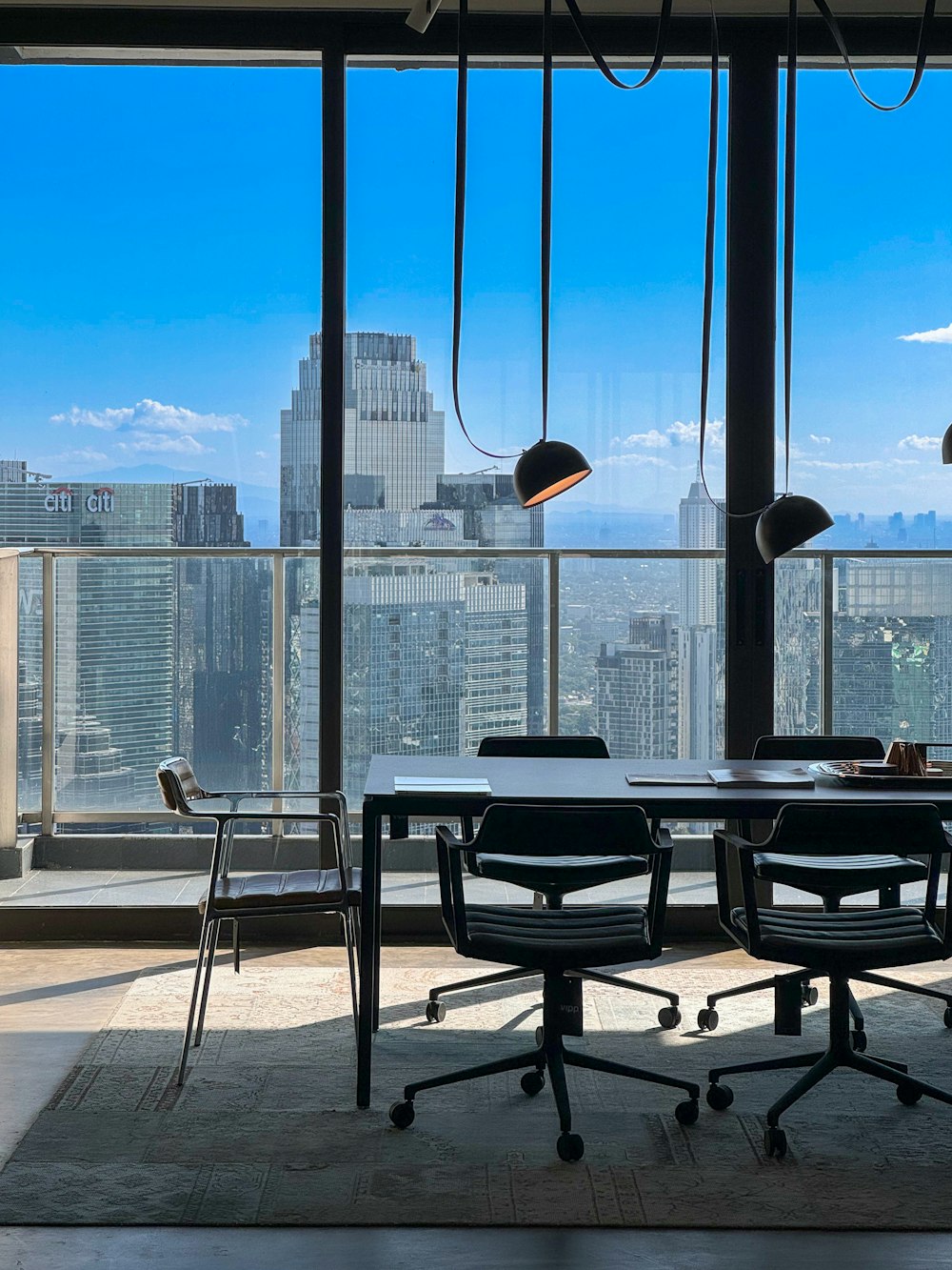 a table and chairs in a room with a view of a city