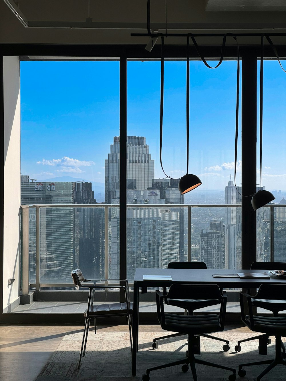 a table and chairs in a room with a view of a city