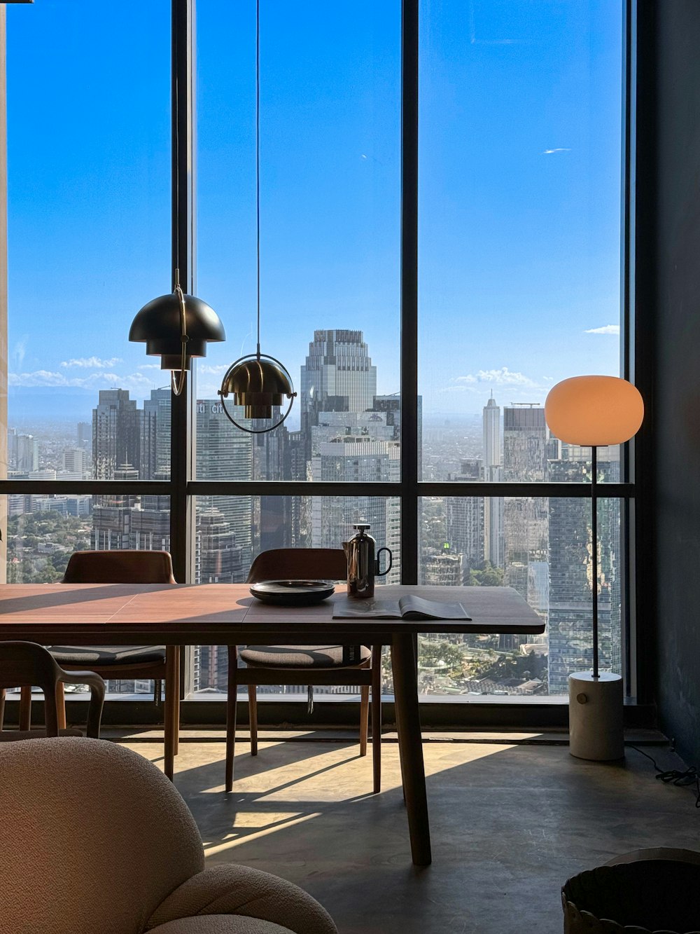 a room with a table, chairs and a view of the city