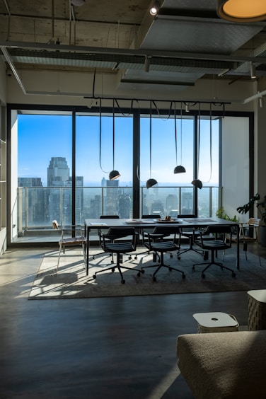 a room with a table and chairs and a view of the city
