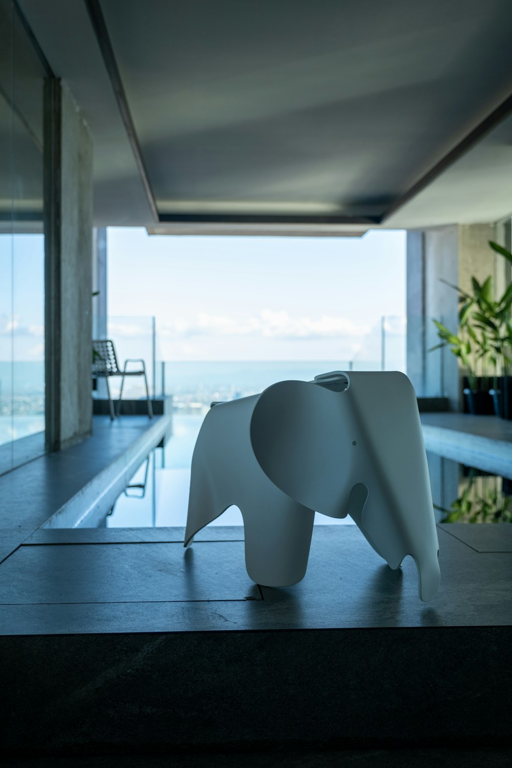 a white elephant statue sitting in front of a swimming pool