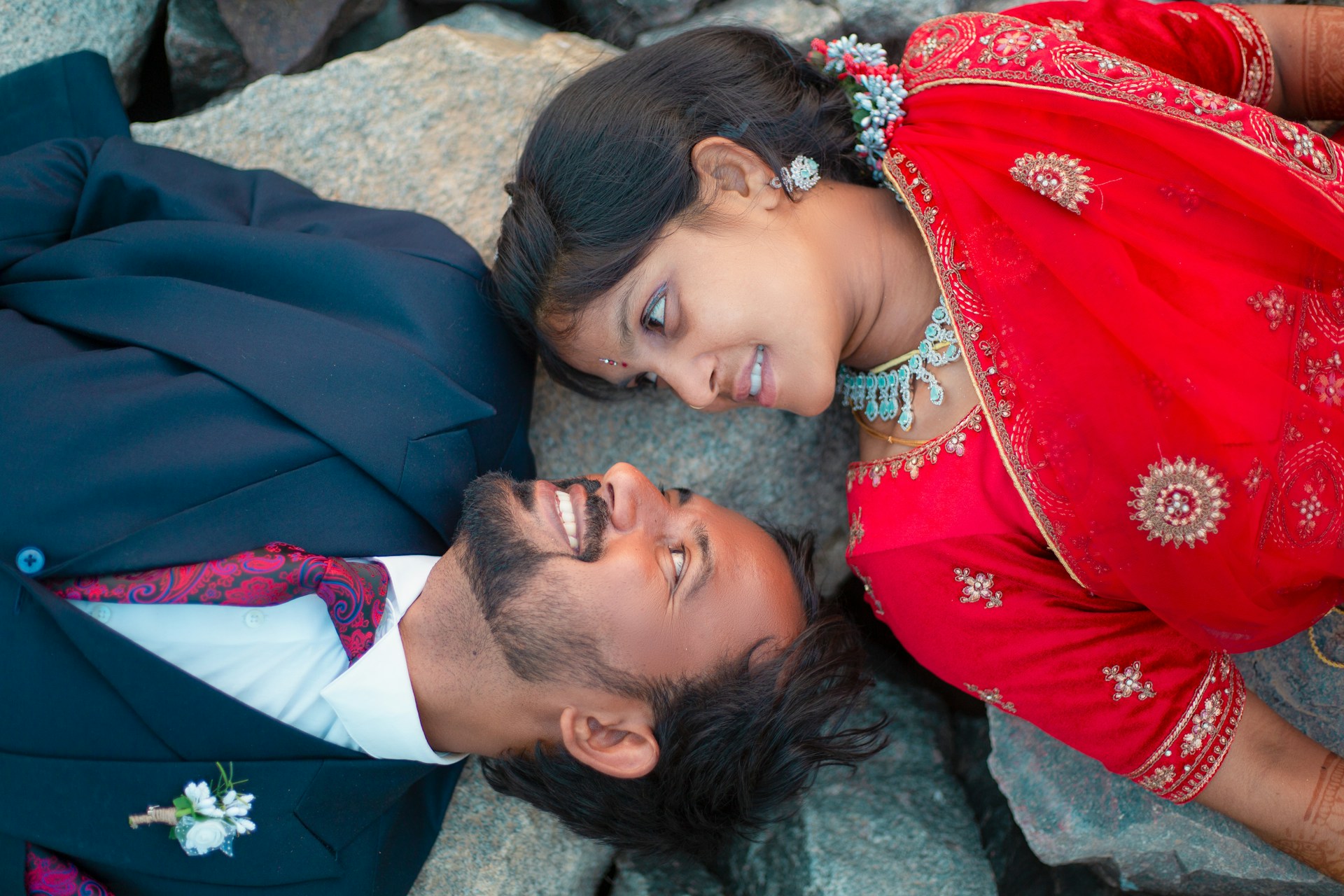 a man and a woman laying on a rock