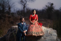 a woman in a red dress and a man in a blue suit sitting on a