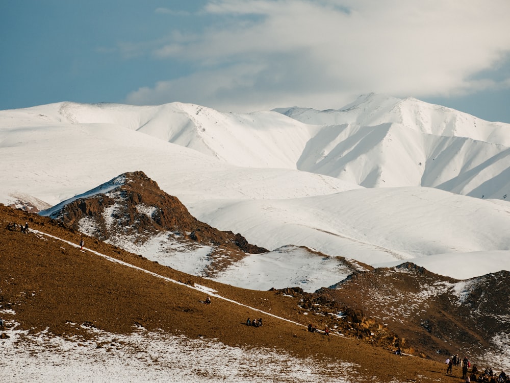 un groupe de personnes debout au sommet d’une montagne enneigée