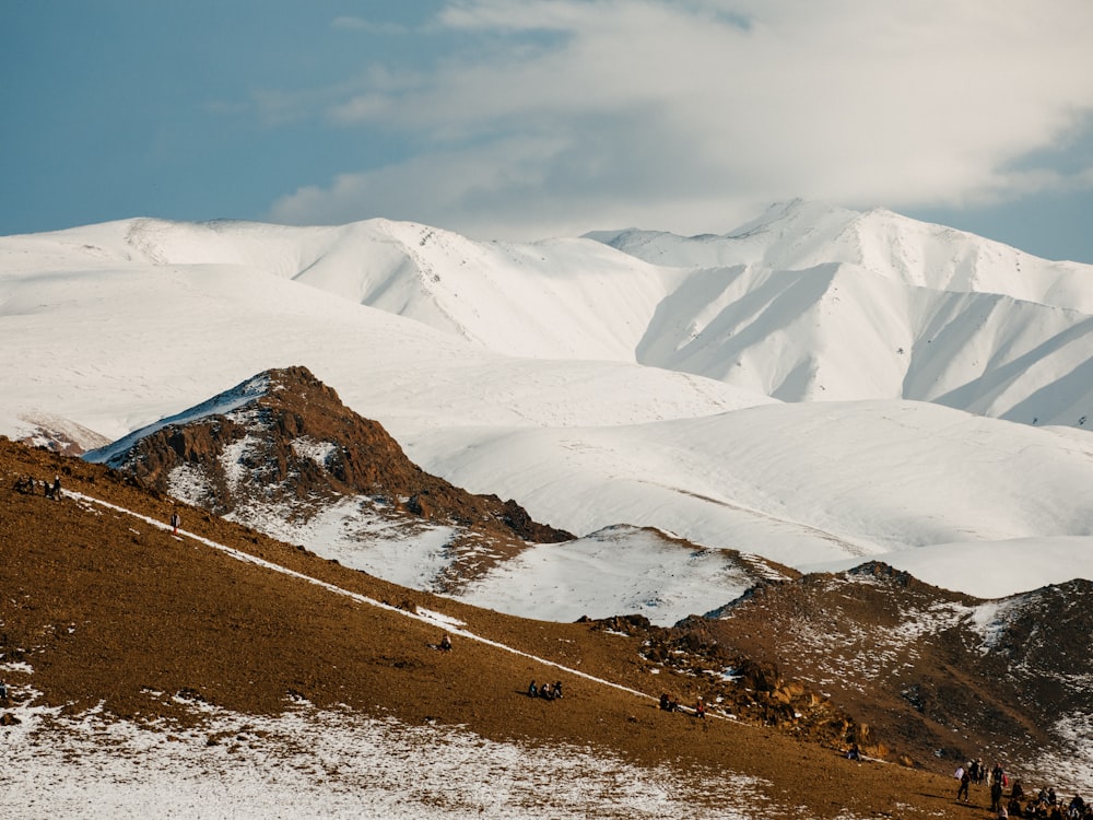 雪に覆われた山の頂上に立つ人々のグループ
