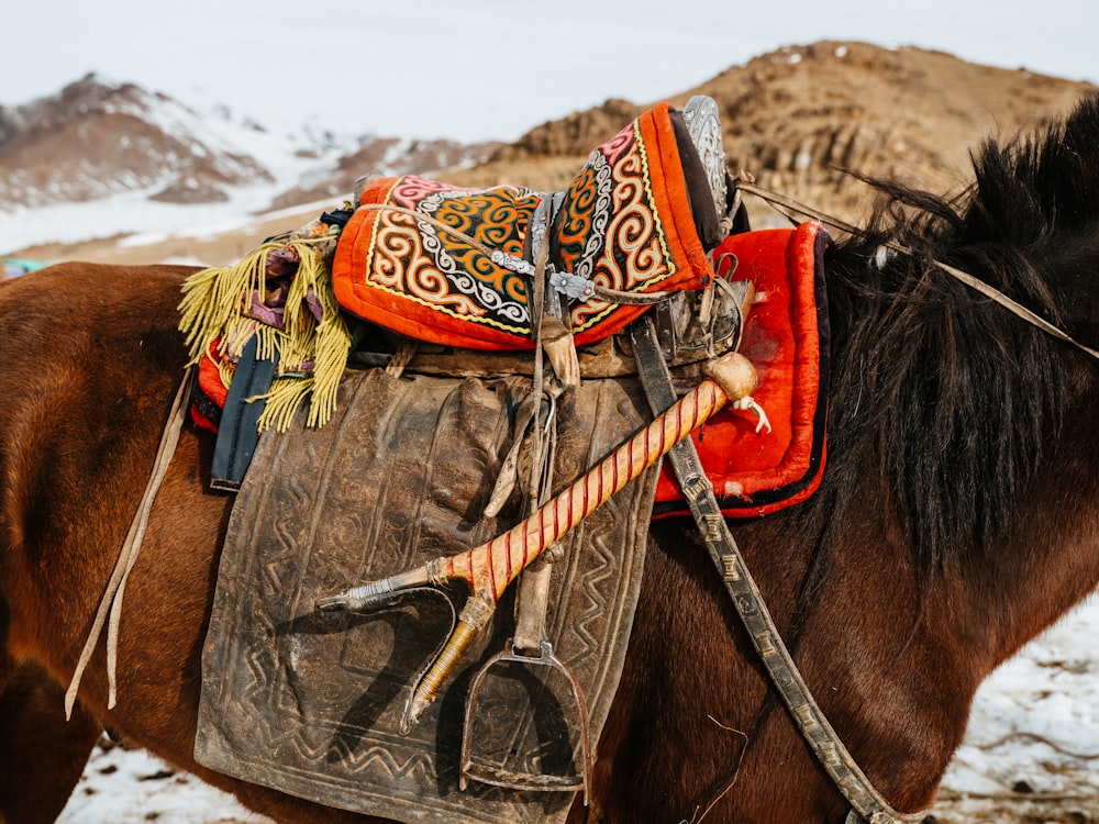 un caballo marrón con una silla de montar en el lomo