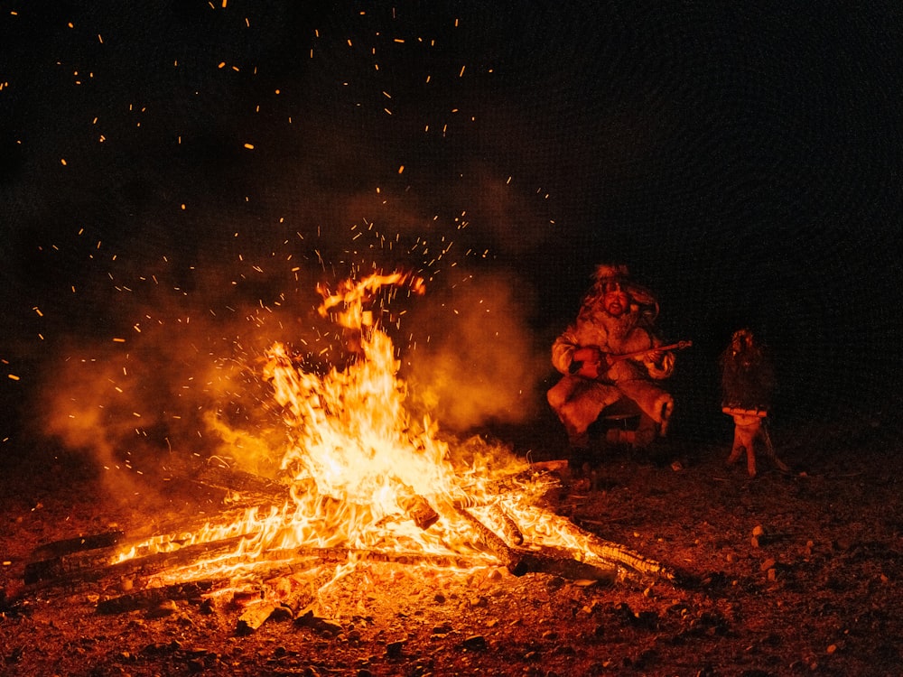 a group of people sitting around a fire