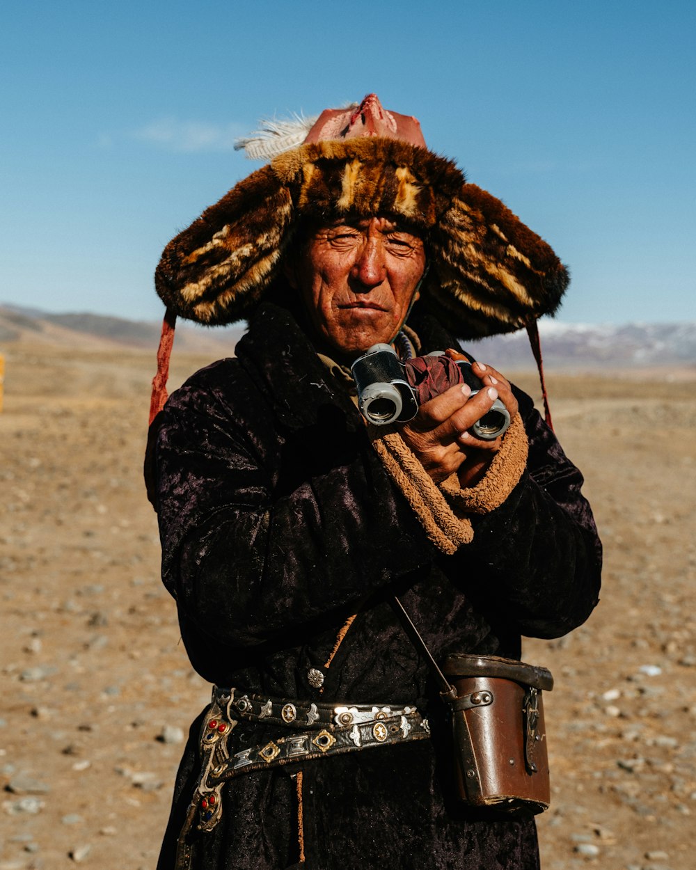 a man in a fur hat holding a camera