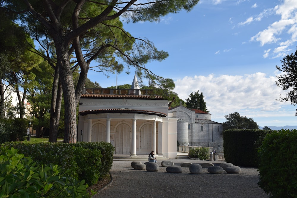 a large white building surrounded by trees and bushes